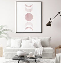 Load image into Gallery viewer, Black-Framed Moon Phases Watercolor Print in Bage and Brown on a living room wall