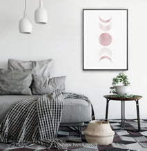 Load image into Gallery viewer, Black-Framed Moon Phases Watercolor Print in Bage and Brown on a bedroom wall