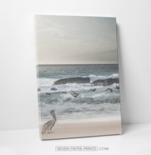 Load image into Gallery viewer, A stretched canvas of an ocean shore with a pelican and seagulls