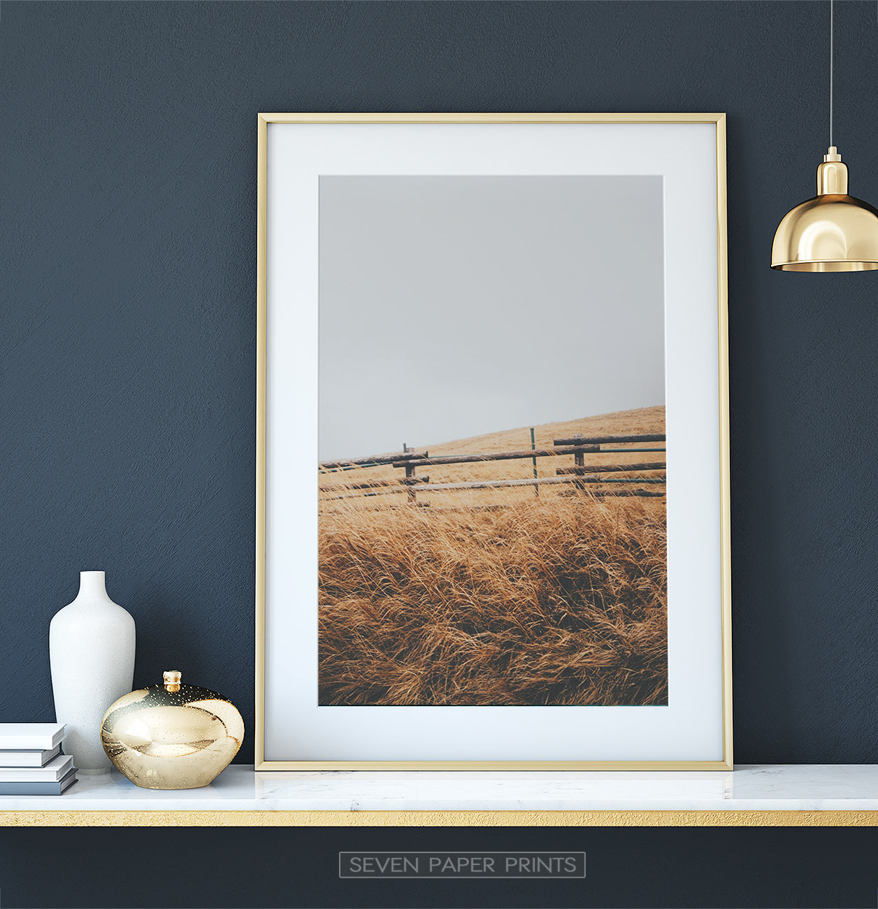 Golden-framed on a white marble shelf