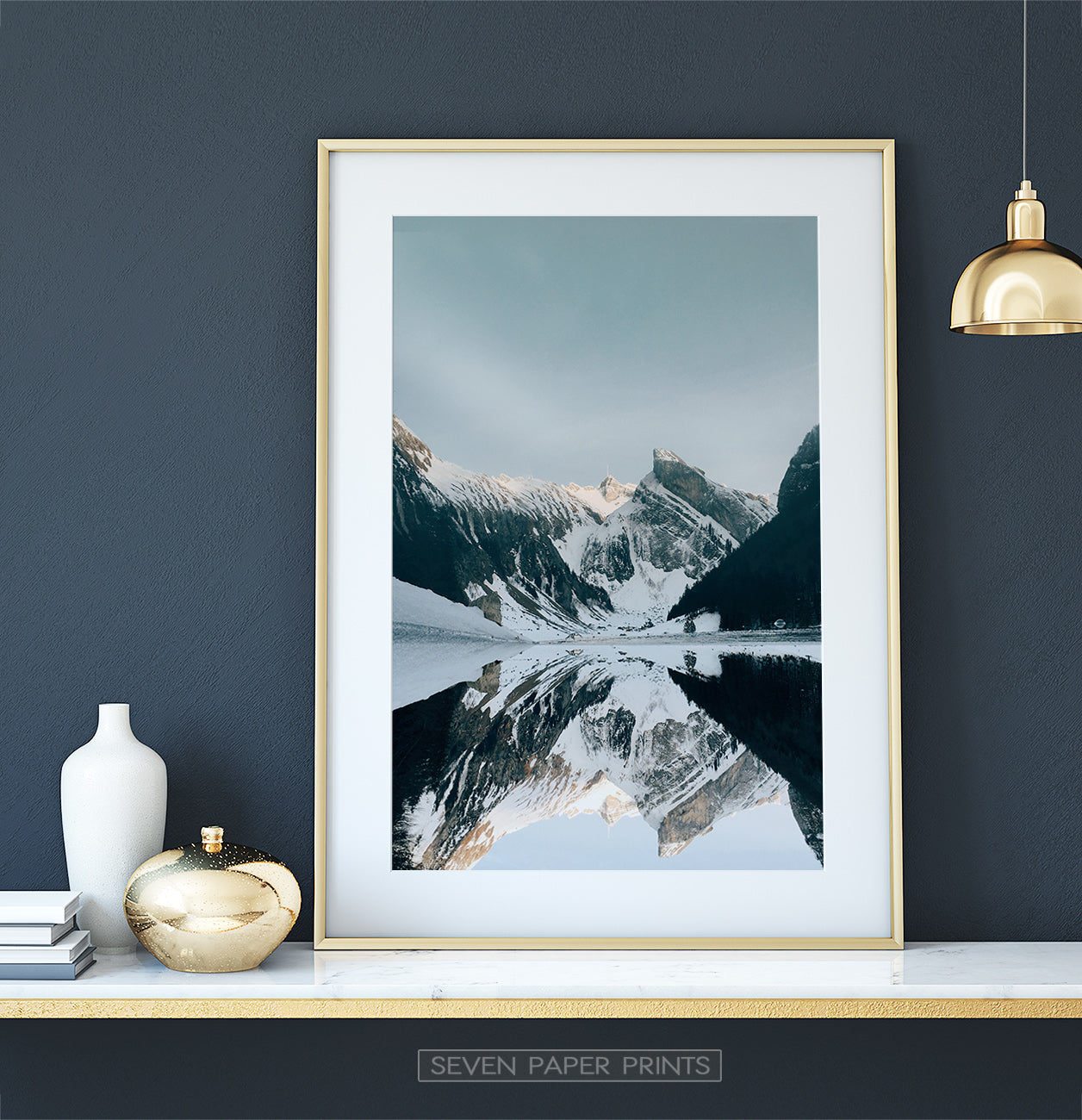 Golden-framed on a white marble shelf