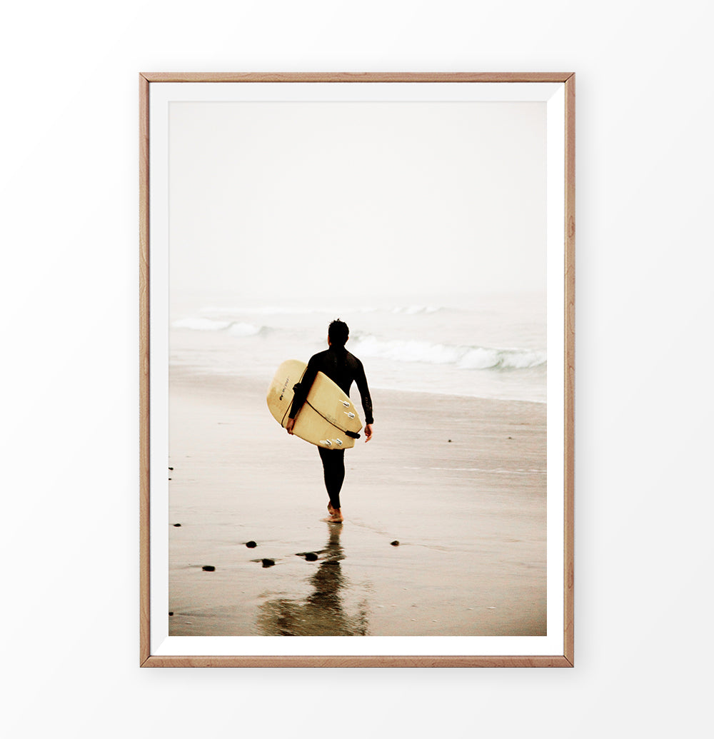 Surfer with yellow surfboard walking toward ocean