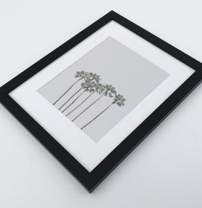 A framed photo print with palms