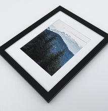 Load image into Gallery viewer, A photo print of blue mountains and a forest in black frame
