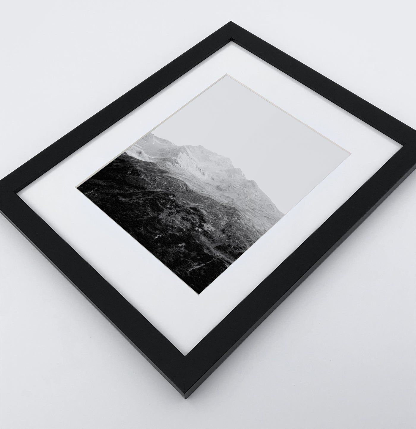 A poster with a foggy mountains landscape in a black frame