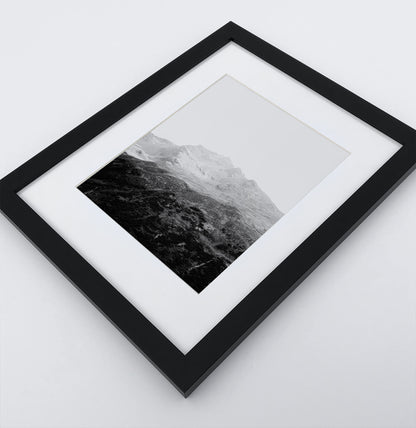 A poster with a foggy mountains landscape in a black frame