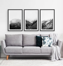 Load image into Gallery viewer, 3 posters of black and white foggy mountain landscapes above a living room sofa
