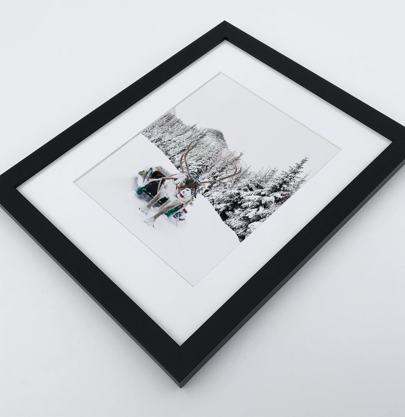 A photo print of a showy forest with a deer pulling the sleigh