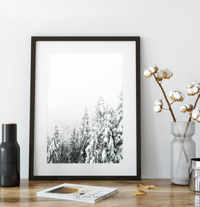 Black-framed Charming Spruce Tops Covered in Snow Photo Art on a table