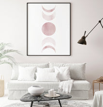 Load image into Gallery viewer, Black-Framed Moon Phases Watercolor Print in Bage and Brown on a living room wall
