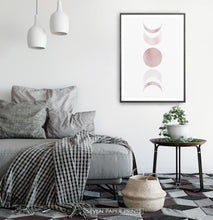Load image into Gallery viewer, Black-Framed Moon Phases Watercolor Print in Bage and Brown on a bedroom wall
