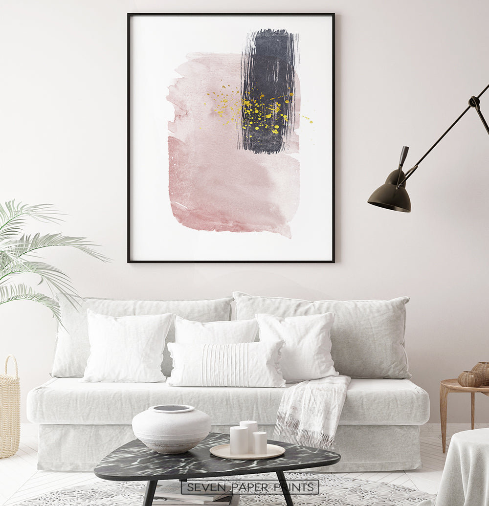 Black-framed Pink and Powder stains under gold drops wall art in a living room