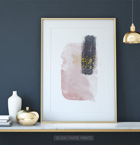 Gold-framed Pink and Powder stains under gold drops wall art on a shelf