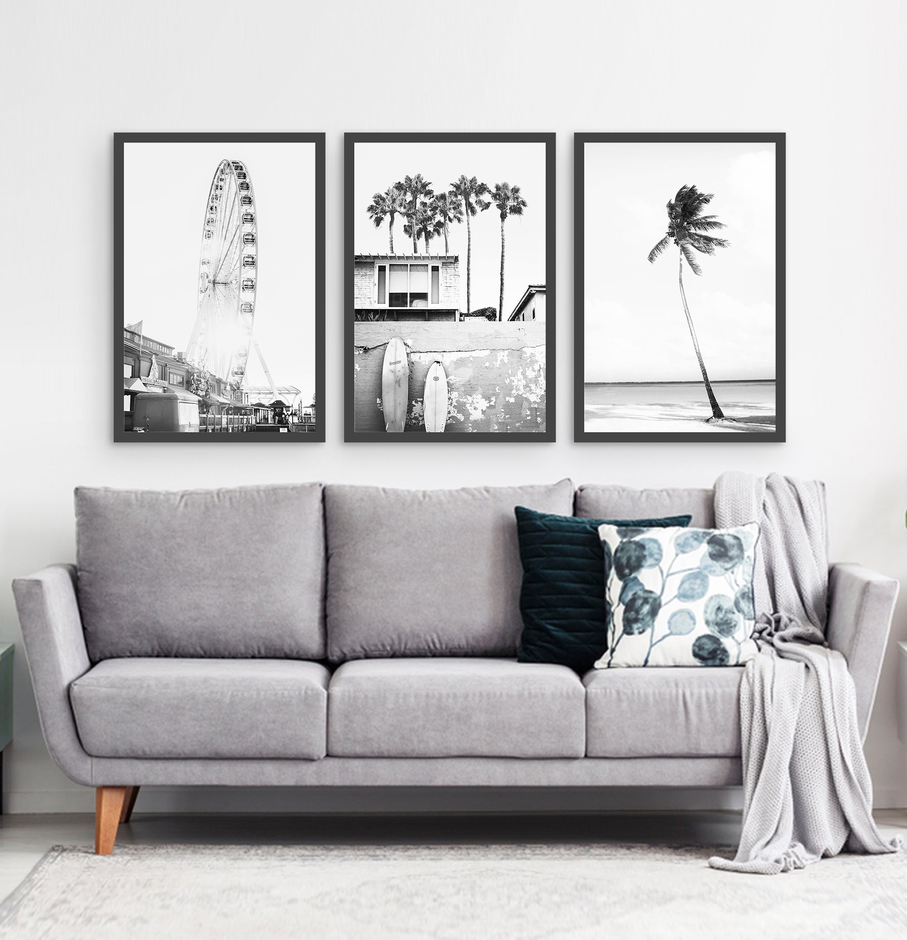 Photos of a ferris wheel, a boat coastal house with surfing boards and a palm on a beach, in frames hanging above the living room sofa