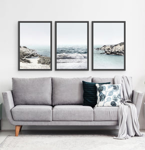 Three white shore of the ocean photos in frames above the sofa
