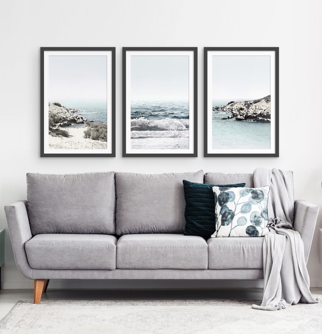 Three white shore of the ocean photos in frames above the sofa