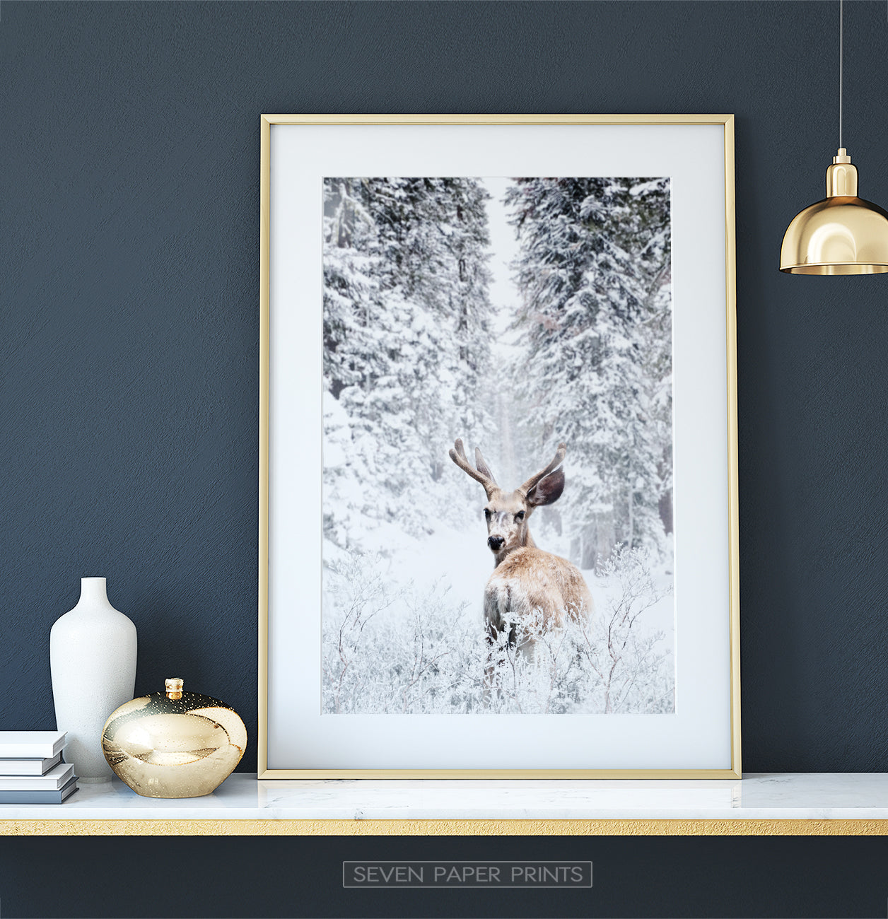Golden-framed on a white marble shelf