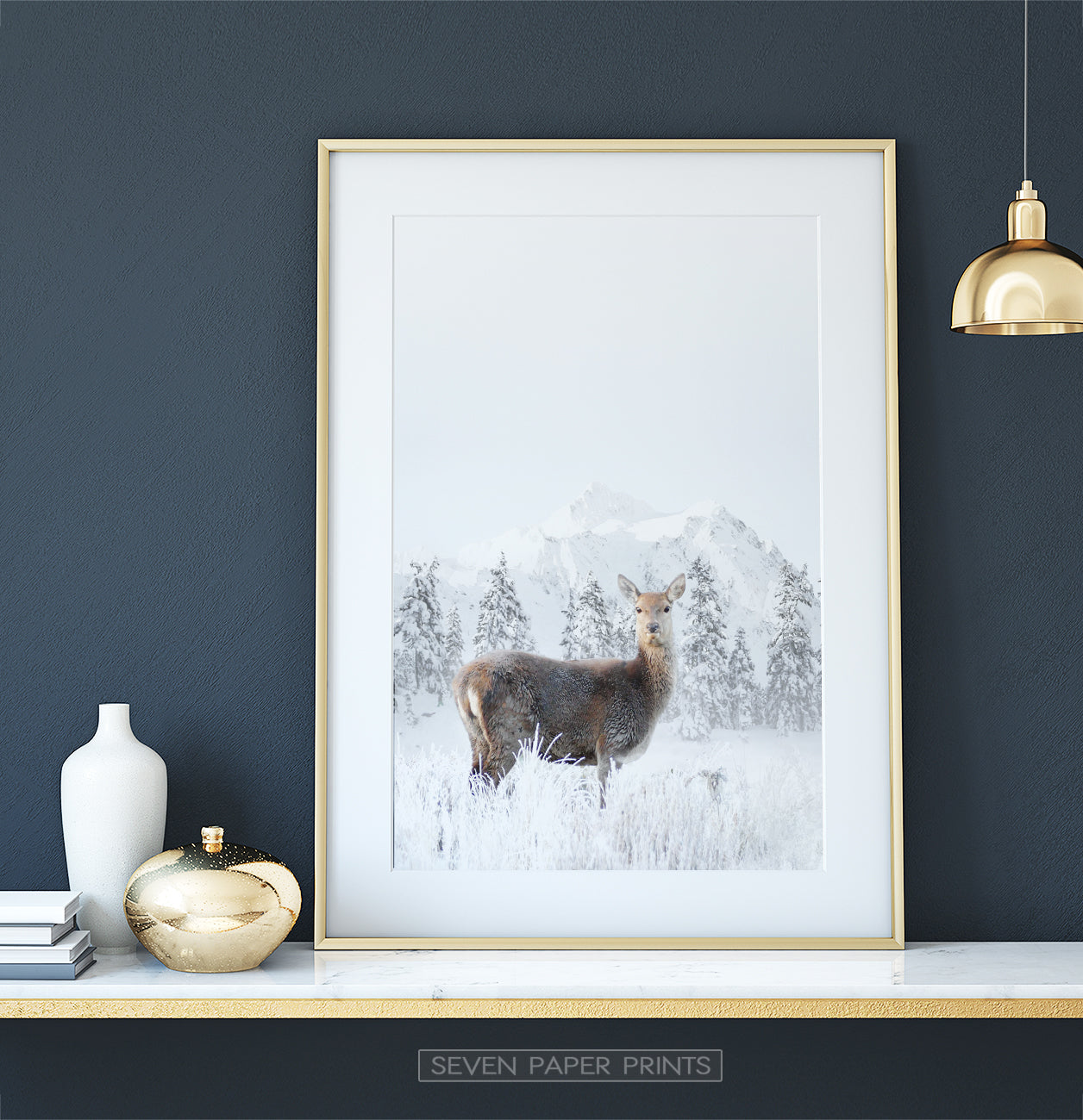 Golden-framed on a white marble shelf