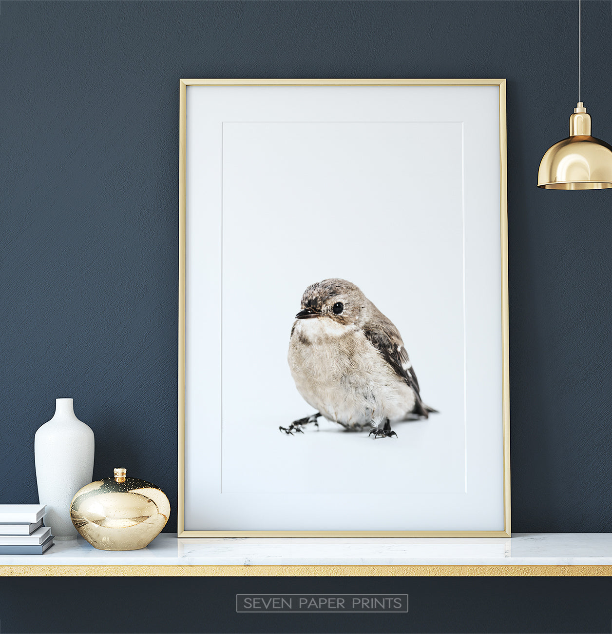 Golden-framed on a white marble shelf
