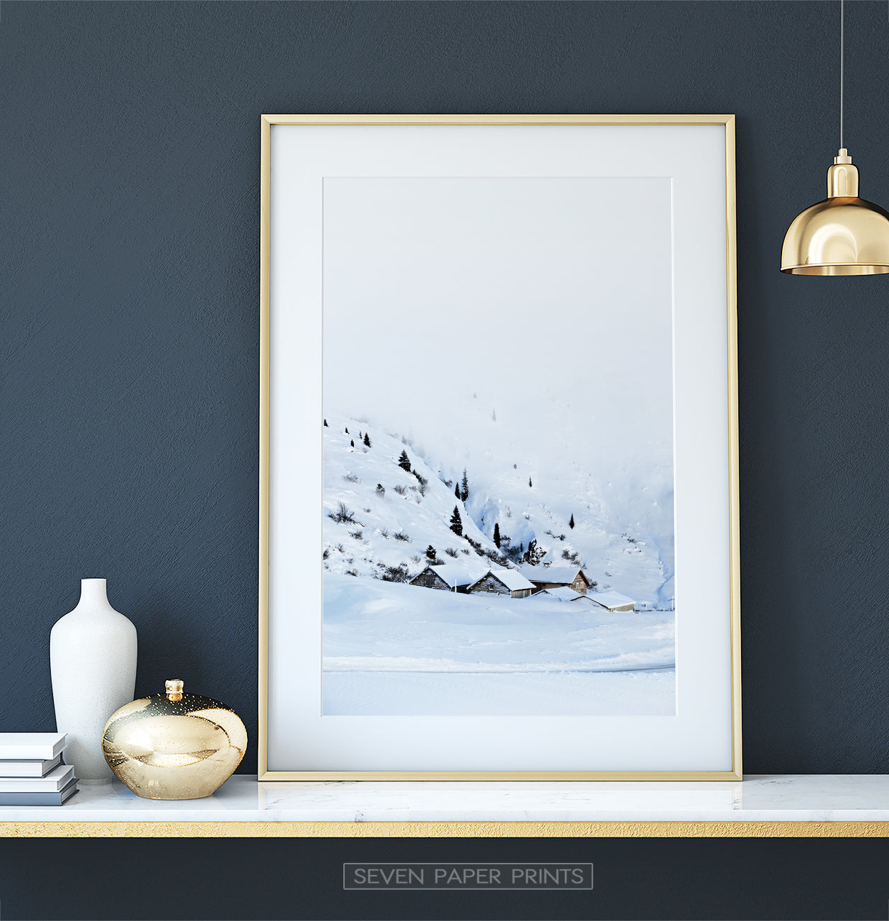Golden-framed on a white marble shelf