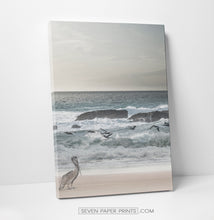 Load image into Gallery viewer, A stretched canvas of an ocean shore with a pelican and seagulls
