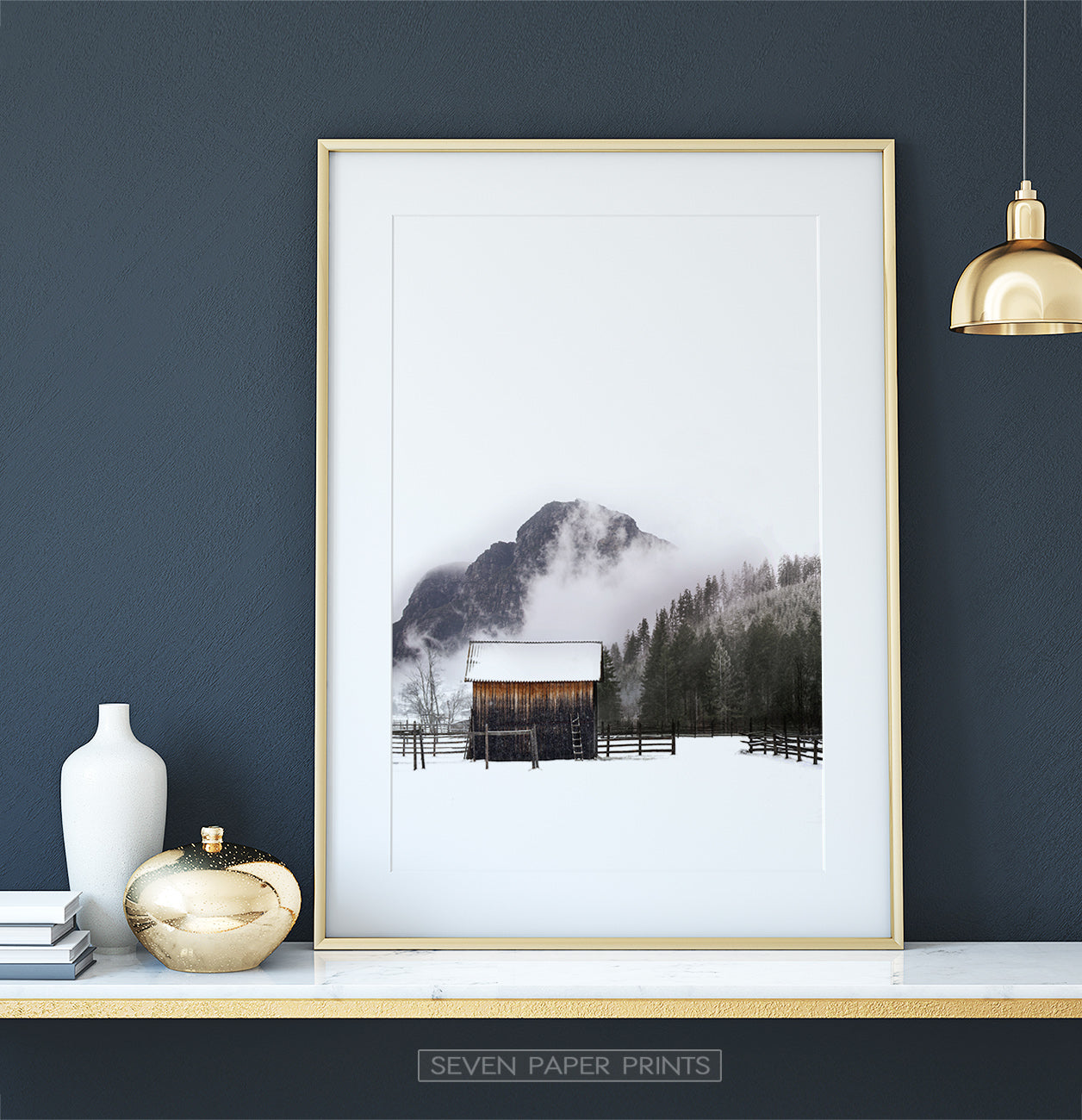 Golden-framed on a white marble shelf